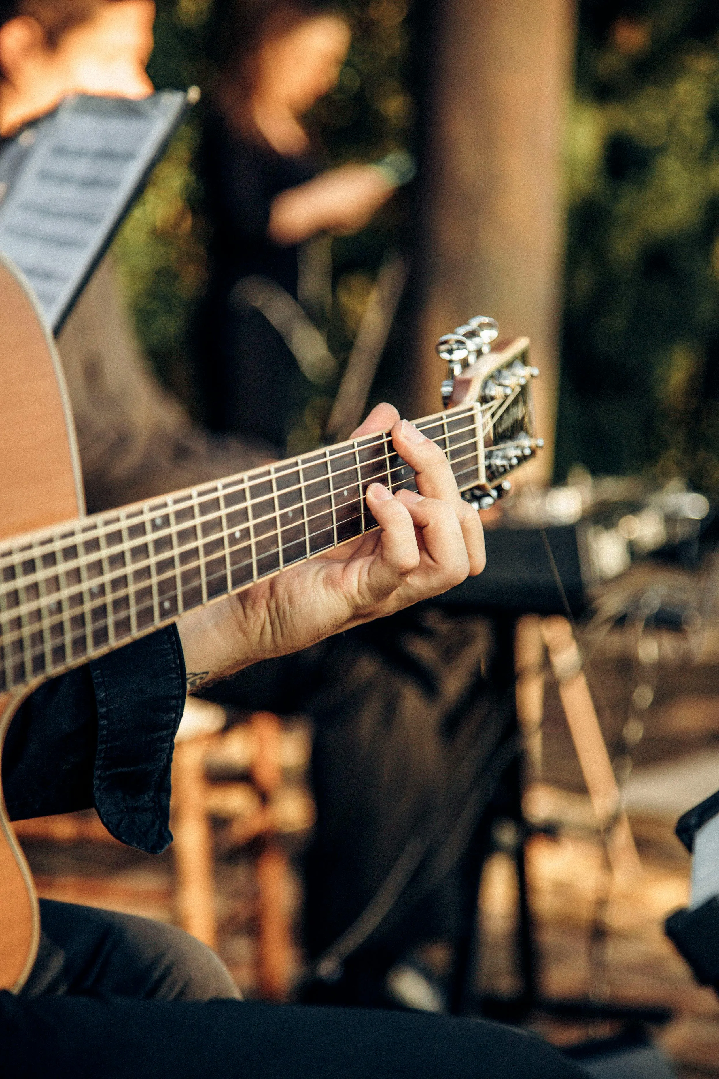 Hands playing a chord in warm evening light