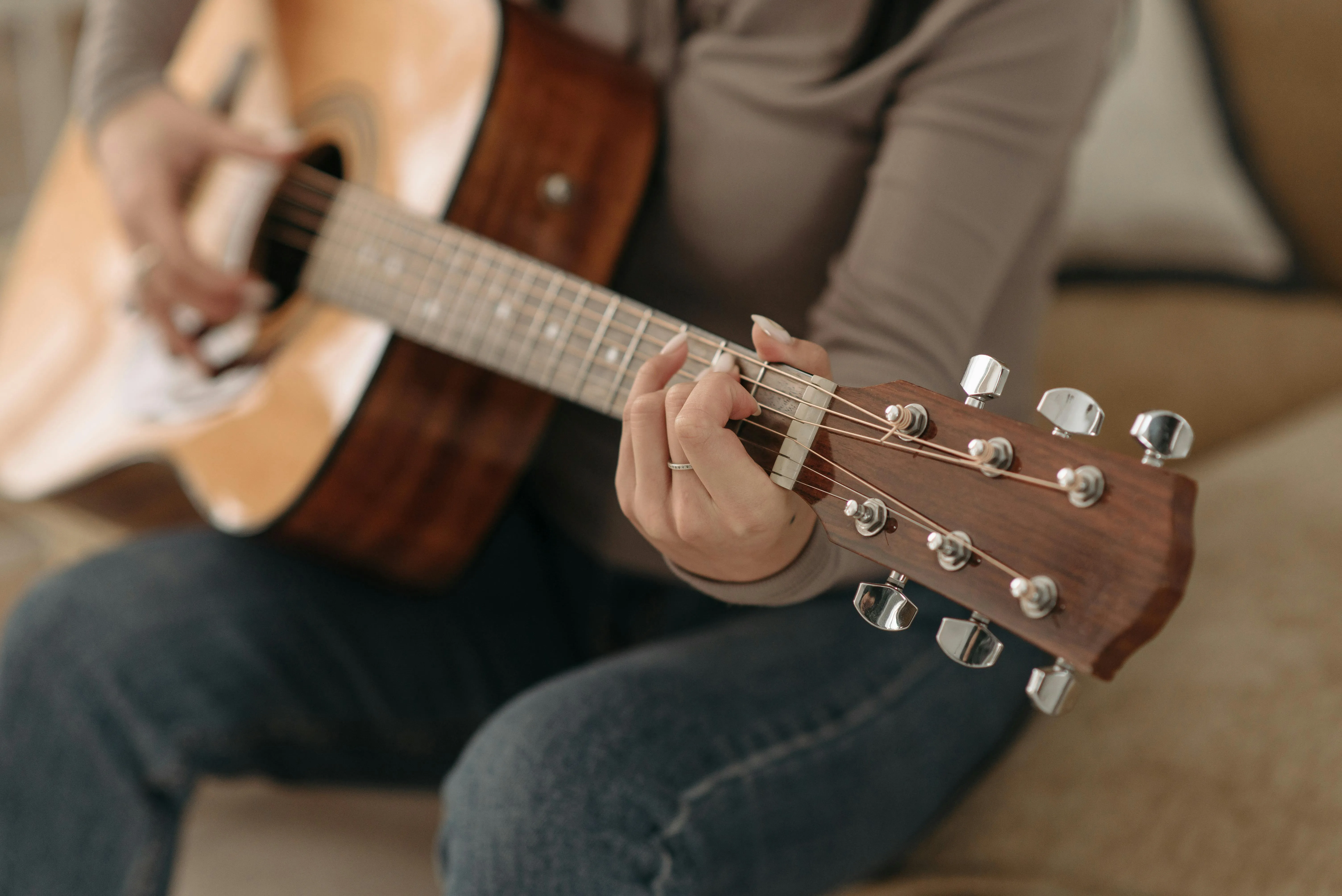 Hands forming a chord on an acoustic guitar