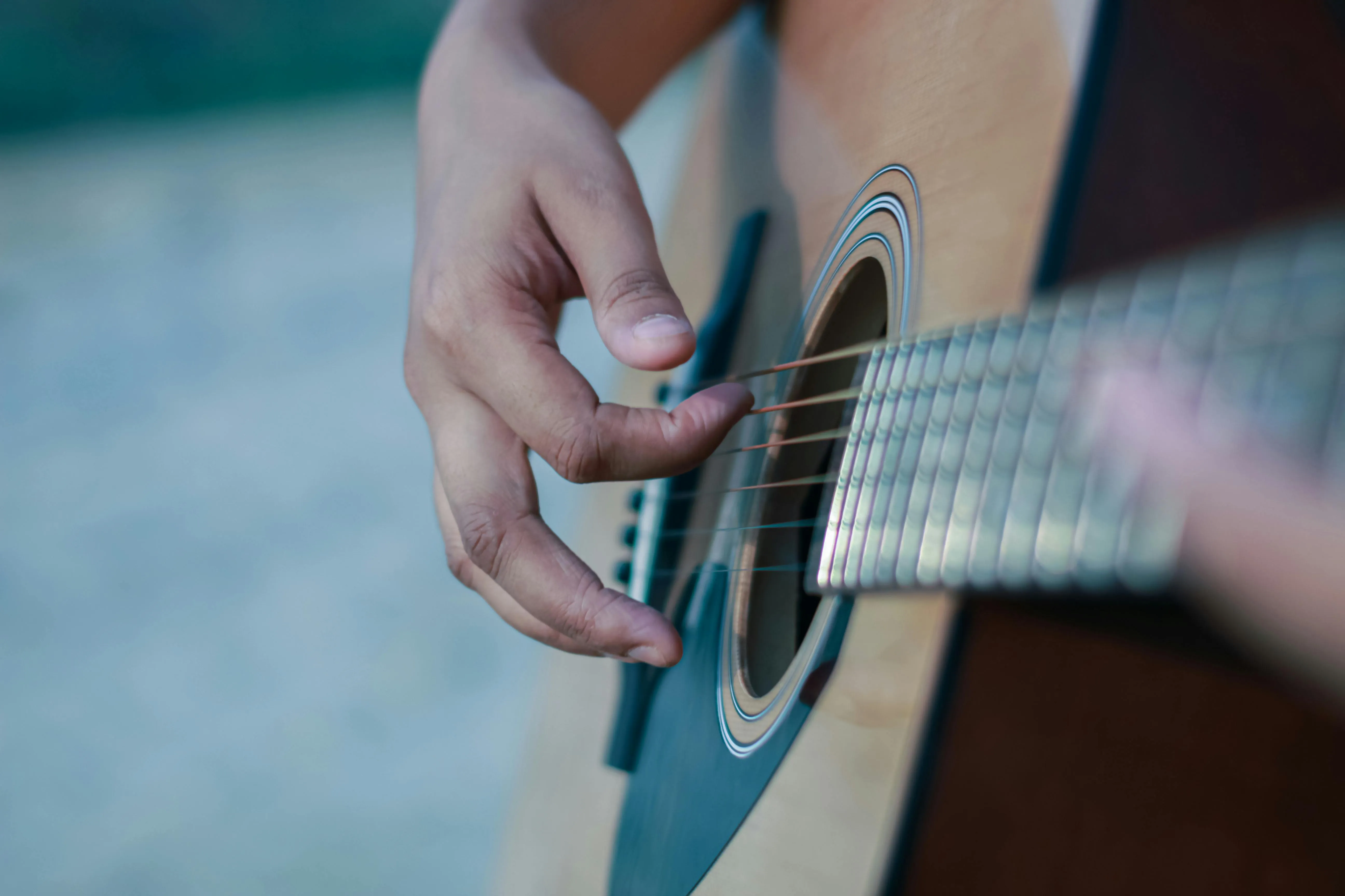 Right hand fingerpicking an acoustic guitar